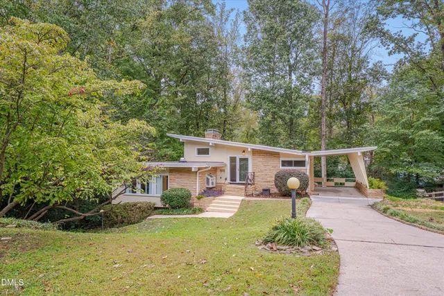 a front view of a house with garden and sitting area