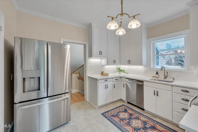 a kitchen with stainless steel appliances granite countertop a sink a stove a refrigerator and island with wooden floor