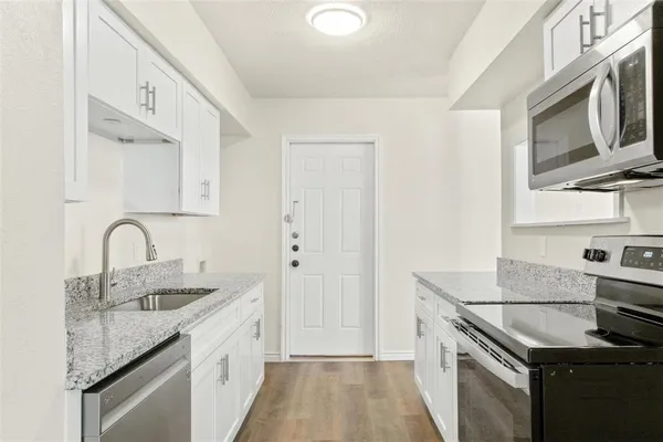 a kitchen with stainless steel appliances granite countertop a sink stove and refrigerator