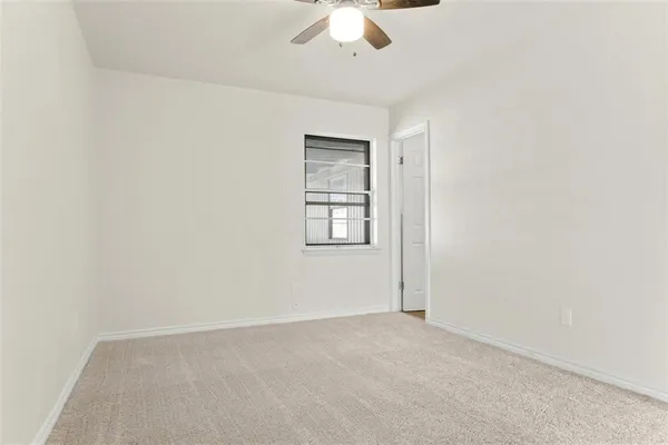 an empty room with chandelier fan