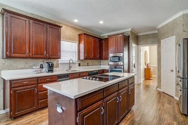 a kitchen with a stove sink and cabinets