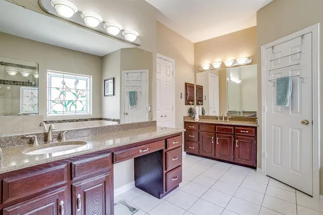 a bathroom with a granite countertop double vanity sink and a mirror
