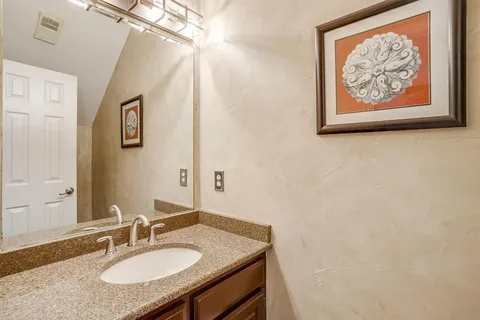 a bathroom with a granite countertop sink and a mirror