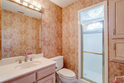 a bathroom with a sink a toilet and shower