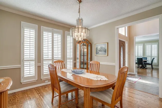 a dining room with furniture a chandelier and wooden floor