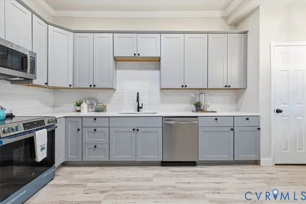a kitchen with stainless steel appliances granite countertop a stove a sink and a microwave