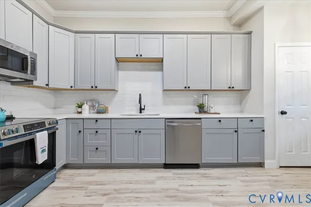 a kitchen with stainless steel appliances granite countertop a stove a sink and a microwave