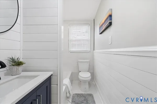 a bathroom with a granite countertop sink a toilet and shower