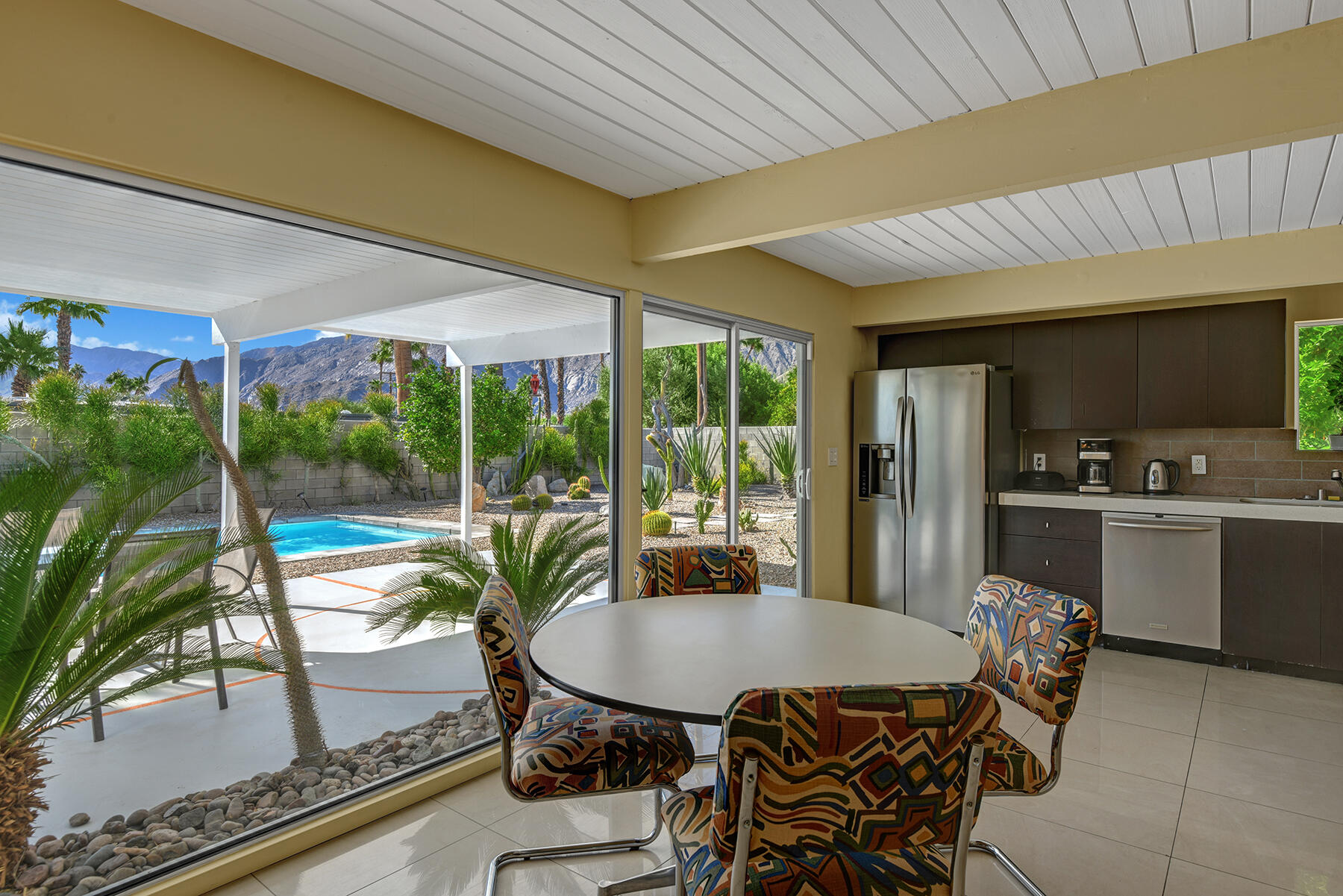 565 East Racquet Club Road Palm Springs, CA 92262 - Photo 8 of 38 DINING ROOM WITH A POOL AND MOUNTAIN VIE