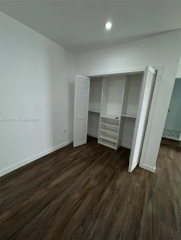 an empty room with wooden floor and closet
