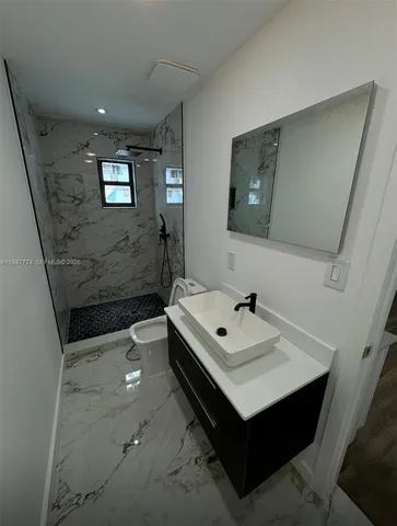 a bathroom with a sink toilet and mirror