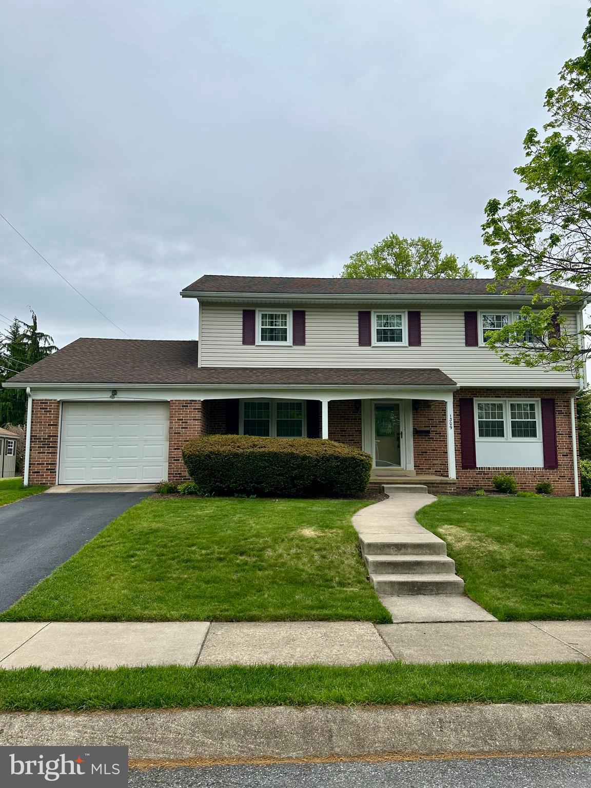 1309 Whitfield Boulevard Reading, PA 19609 - Photo 1 of 1 a front view of a house with a garden and trees