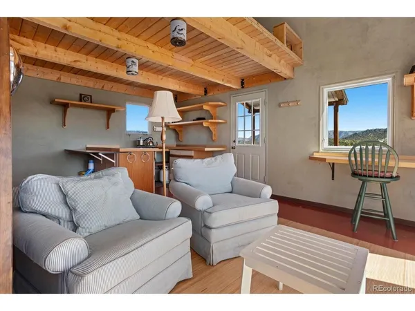 a living room with furniture a wooden floor and a sink