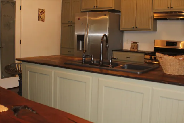 a kitchen with stainless steel appliances granite countertop a sink a stove and a refrigerator