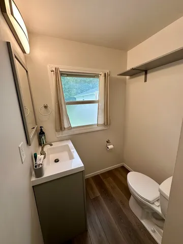 a bathroom with a sink toilet and window