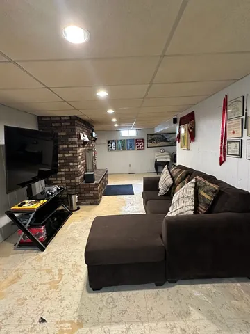 a living room with furniture a flat screen tv and kitchen view
