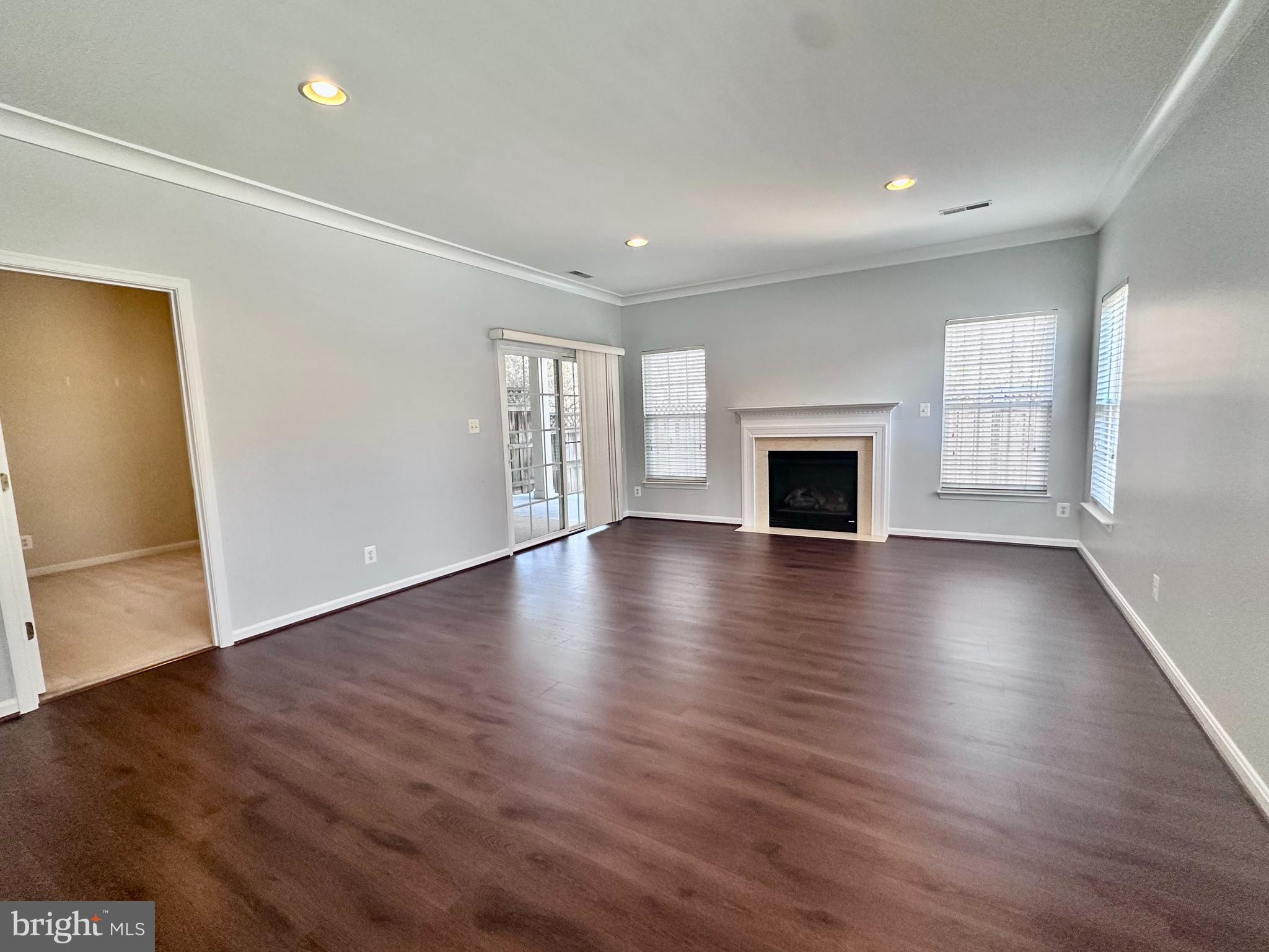 43270 Sunderleigh Square Broadlands, VA 20148 - Photo 18 of 24 an empty room with wooden floor fireplace and windows