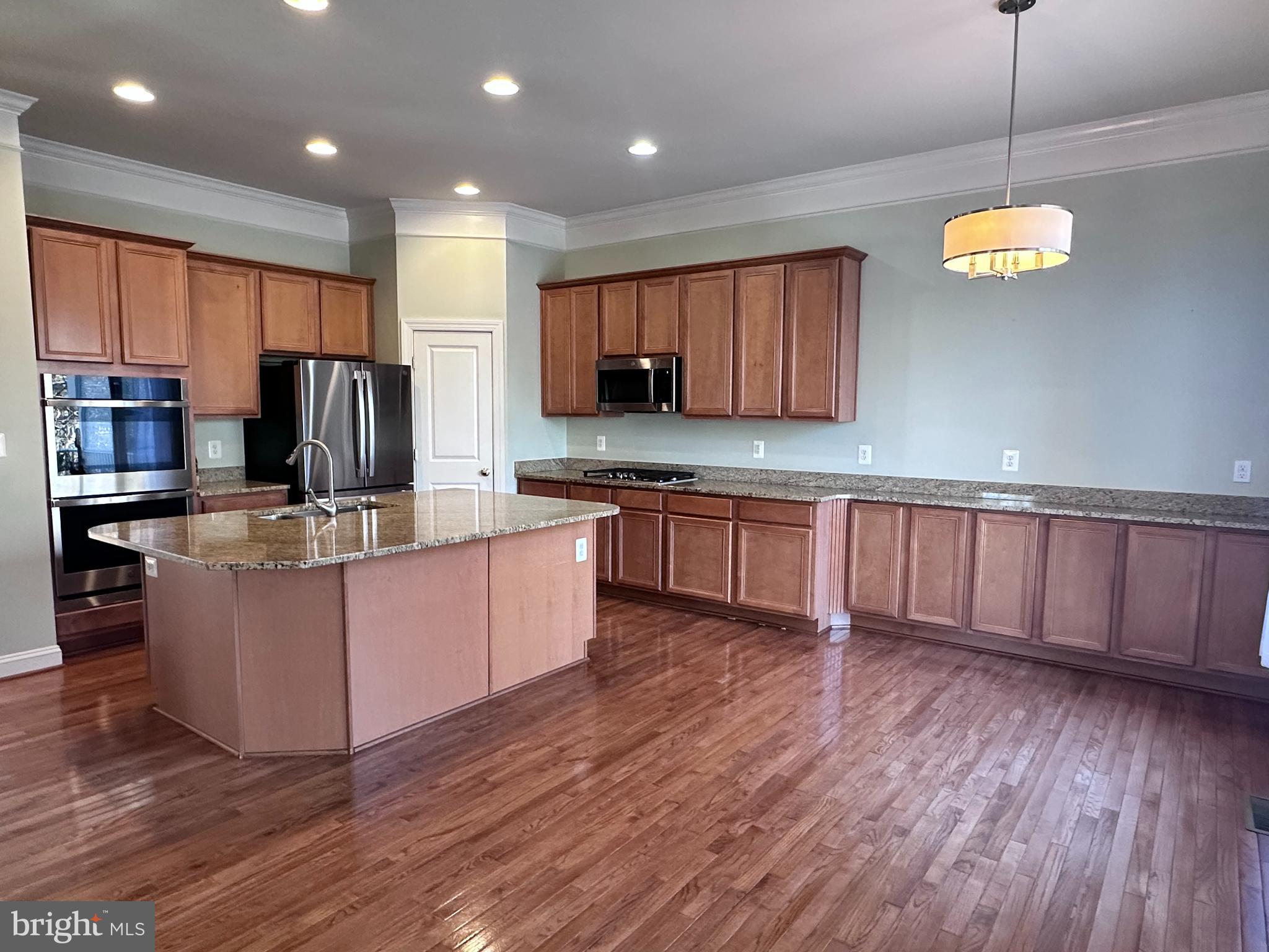 43270 Sunderleigh Square Broadlands, VA 20148 - Photo 3 of 24 a kitchen with stainless steel appliances granite countertop wooden cabinets a stove a sink and a center