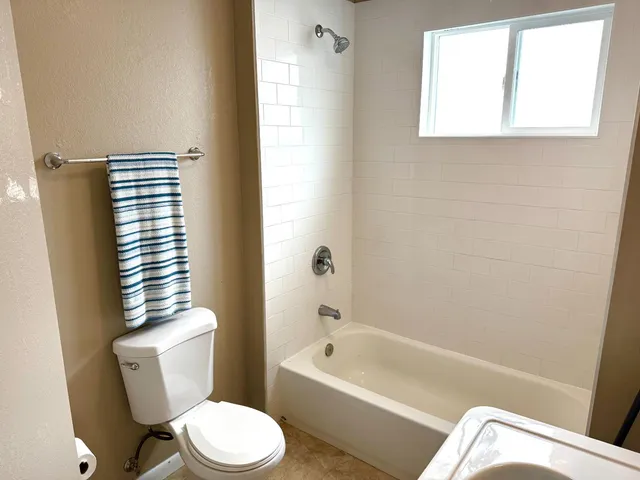 a white toilet sitting next to a bath tub