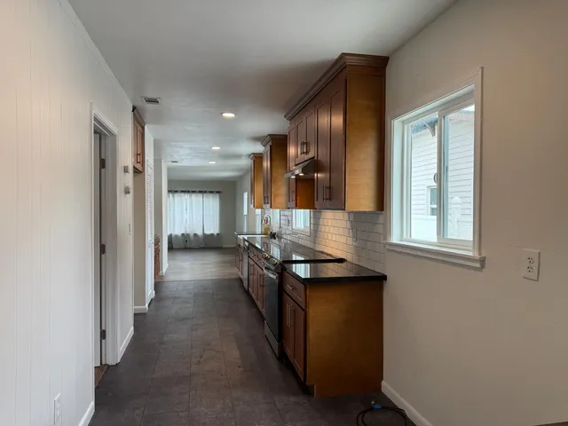 a dining hall with stainless steel appliances granite countertop a stove and a refrigerator