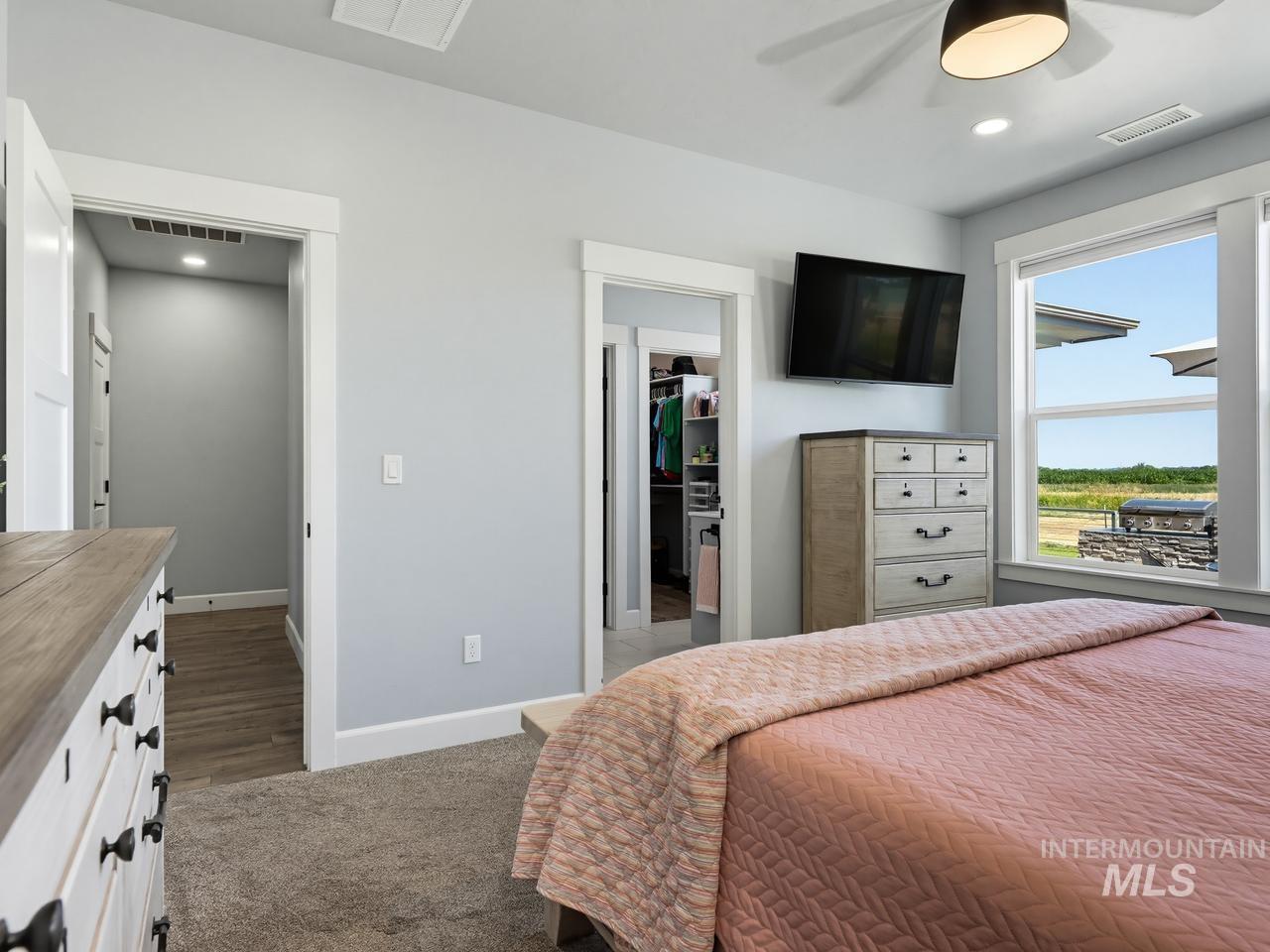 4950 West Columbia Road Nampa, ID 83687 - Photo 24 of 50 Bright interior featuring a window with exterior views, overhead lighting, an open doorway, and carpet flooring
