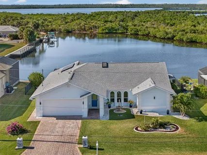 an aerial view of a house with swimming pool a yard and lake view
