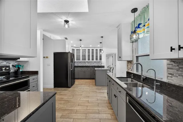 a kitchen with stainless steel appliances granite countertop a sink stove and refrigerator