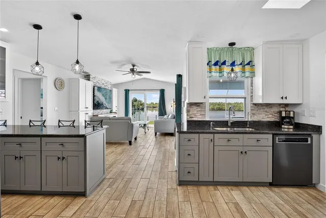 a kitchen with granite countertop a sink cabinets and wooden floor