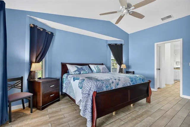 a bedroom with a bed and wooden floor