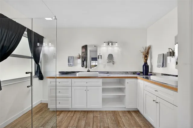 a kitchen with white cabinets and sink