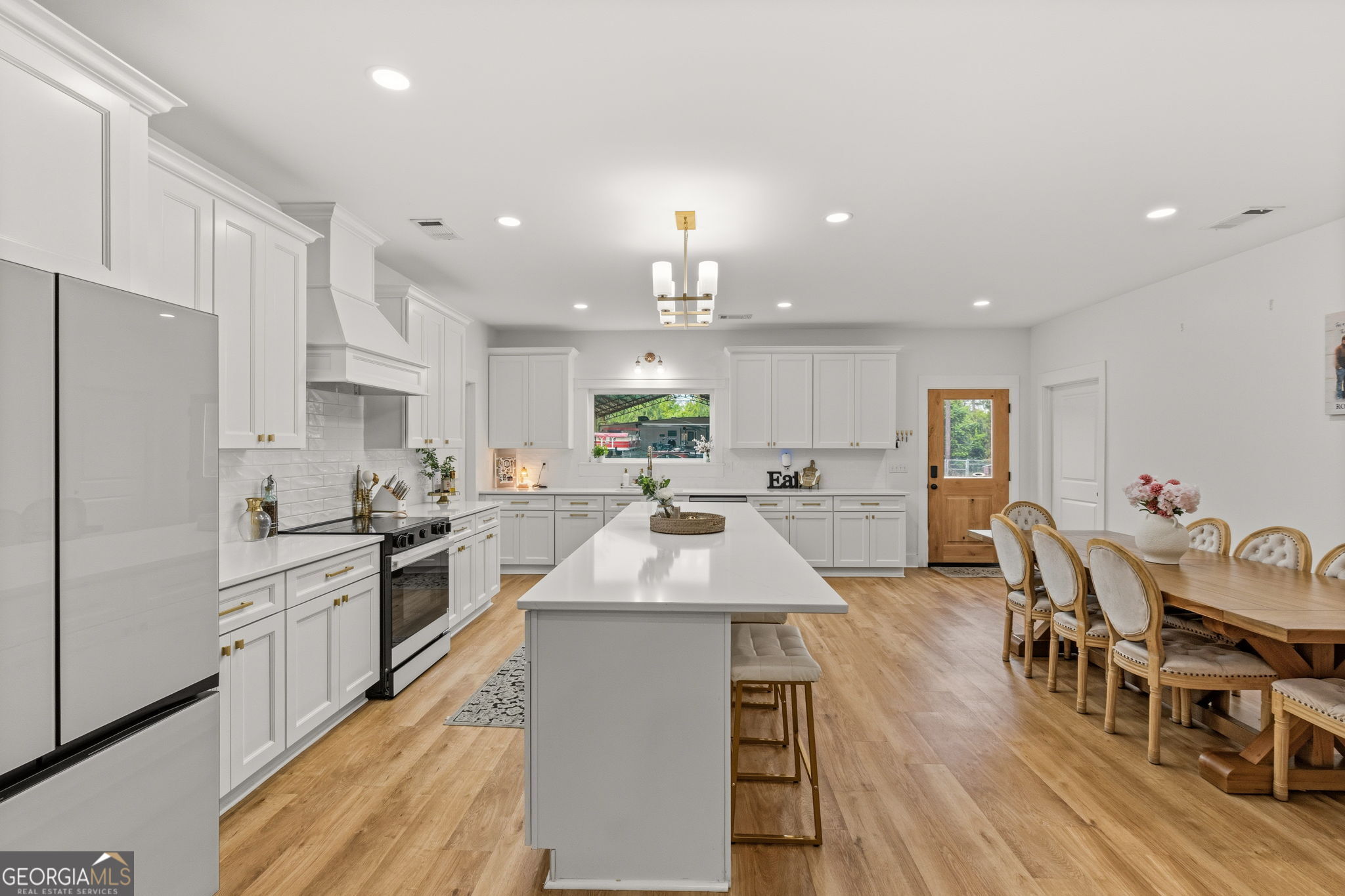 51 Prong Road Swainsboro, GA 30401 - Photo 13 of 55 a large kitchen with kitchen island a island a stove a refrigerator a dining table and chairs with wooden floor