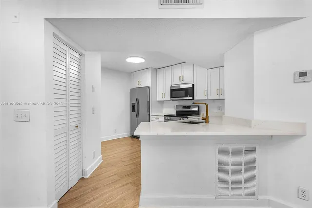 a kitchen with stainless steel appliances a refrigerator and a stove top oven