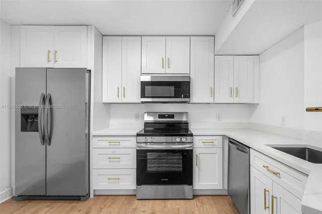 a kitchen with cabinets stainless steel appliances and a counter space
