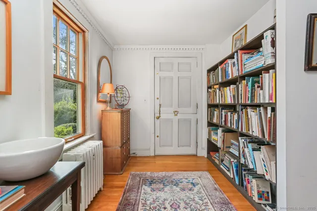 a living room with furniture a rug and a book shelf