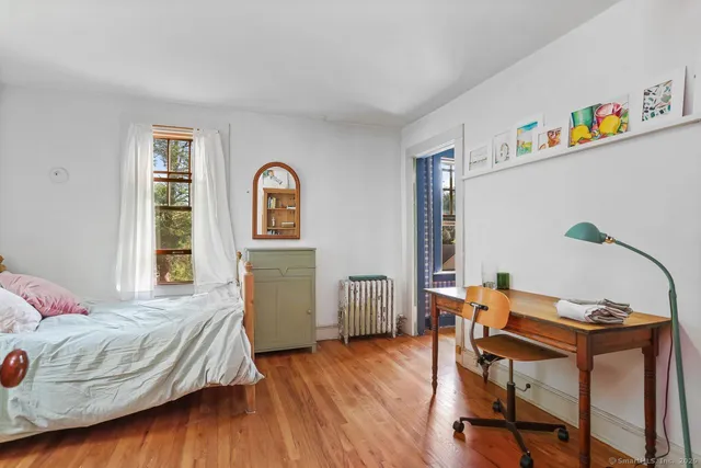 a bedroom with a bed and wooden floor