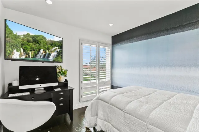 a bedroom with a bed and a flat screen tv