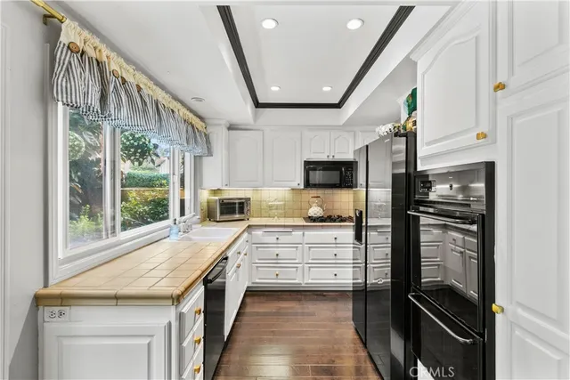 a kitchen with white cabinets and appliances
