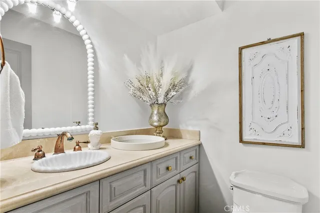 a bathroom with a granite countertop sink mirror vanity and toilet