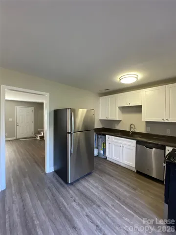 a large kitchen with a wooden floor and stainless steel appliances