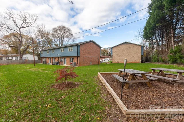 a view of a house with backyard and sitting area