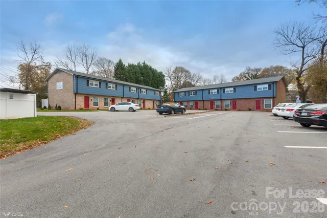 a city view with tall buildings and cars parked in front of it