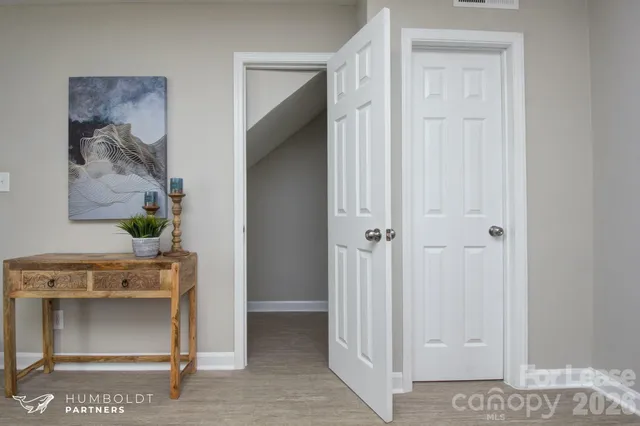 a view of a hallway to rooms and stairs