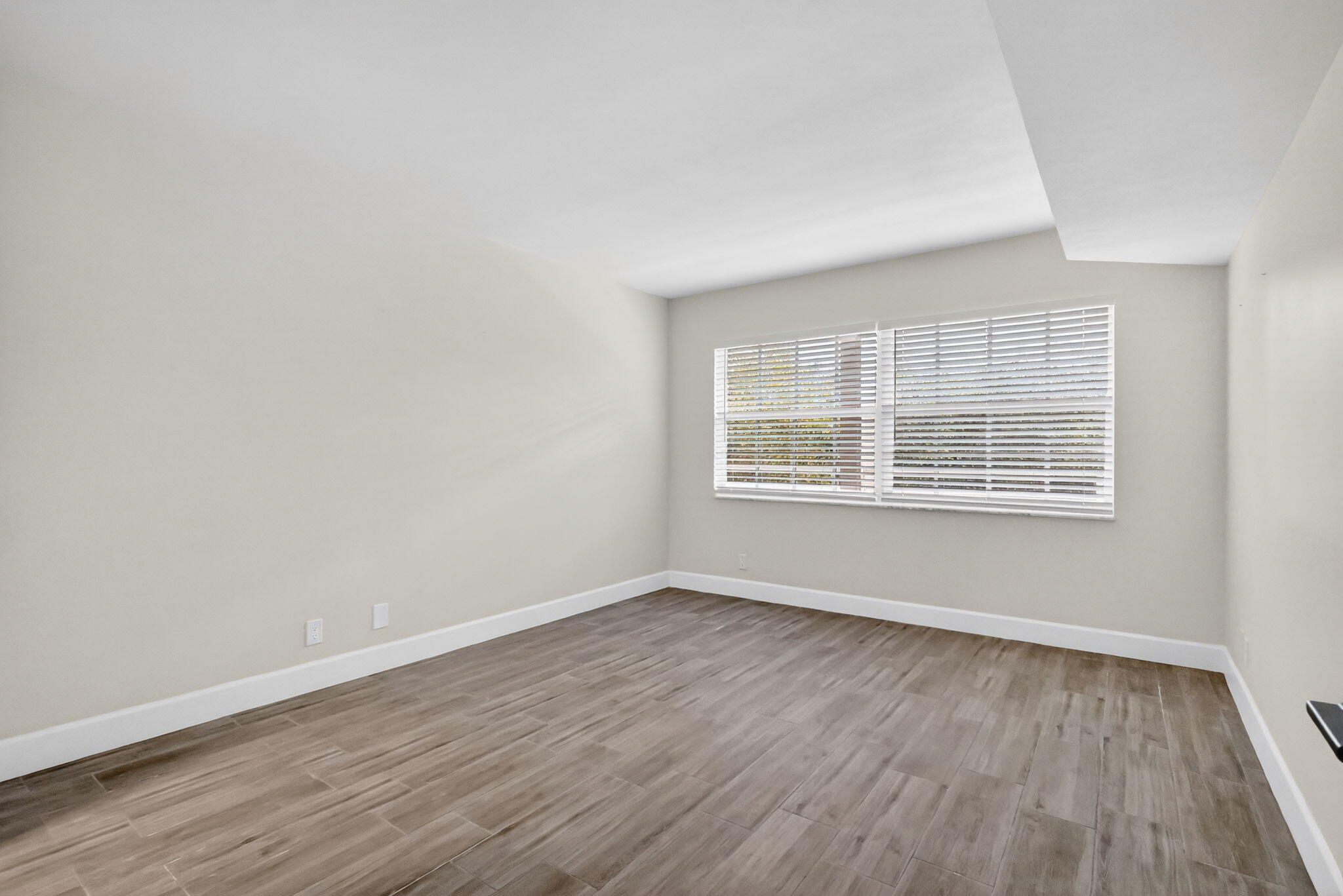 545 Oaks Lane, Unit 409 Pompano Beach, FL 33069 - Photo 16 of 25 wooden floor in an empty room with a window
