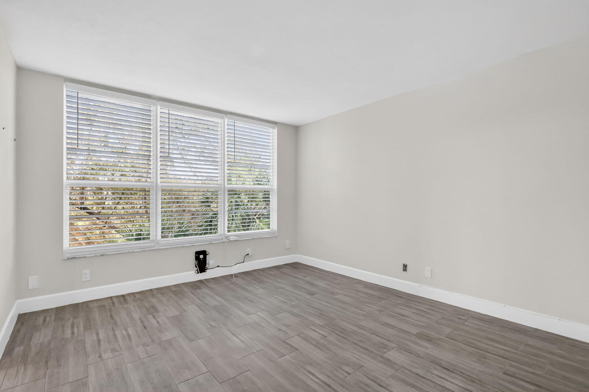 545 Oaks Lane, Unit 409 Pompano Beach, FL 33069 - Photo 20 of 25 a view of an empty room with wooden floor and a window