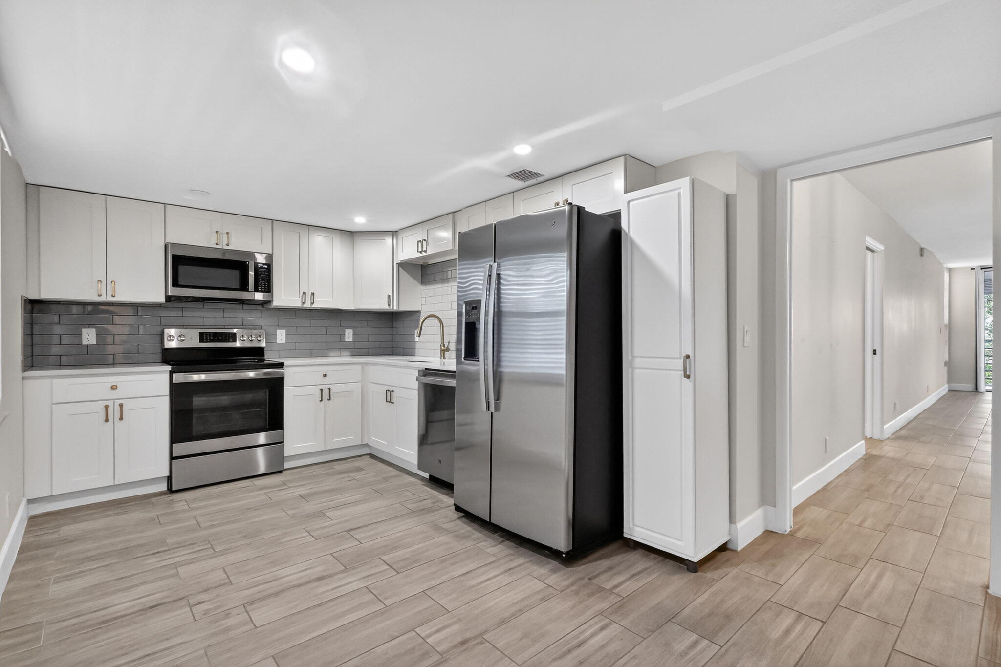 545 Oaks Lane, Unit 409 Pompano Beach, FL 33069 - Photo 2 of 25 a kitchen with granite countertop a refrigerator stove and wooden floor