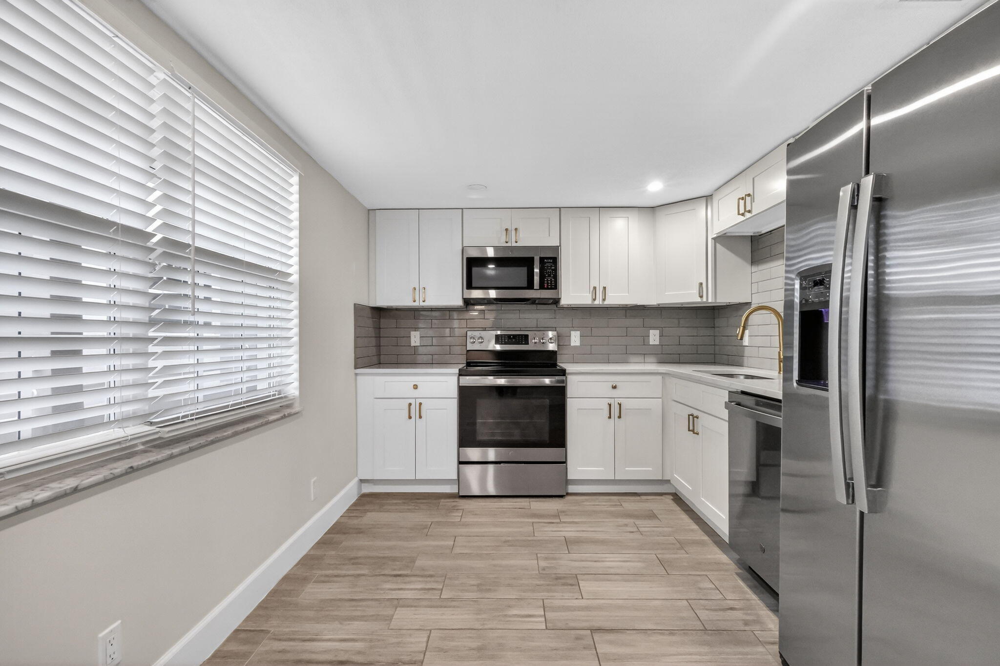545 Oaks Lane, Unit 409 Pompano Beach, FL 33069 - Photo 3 of 25 a kitchen with a stove a sink and a refrigerator