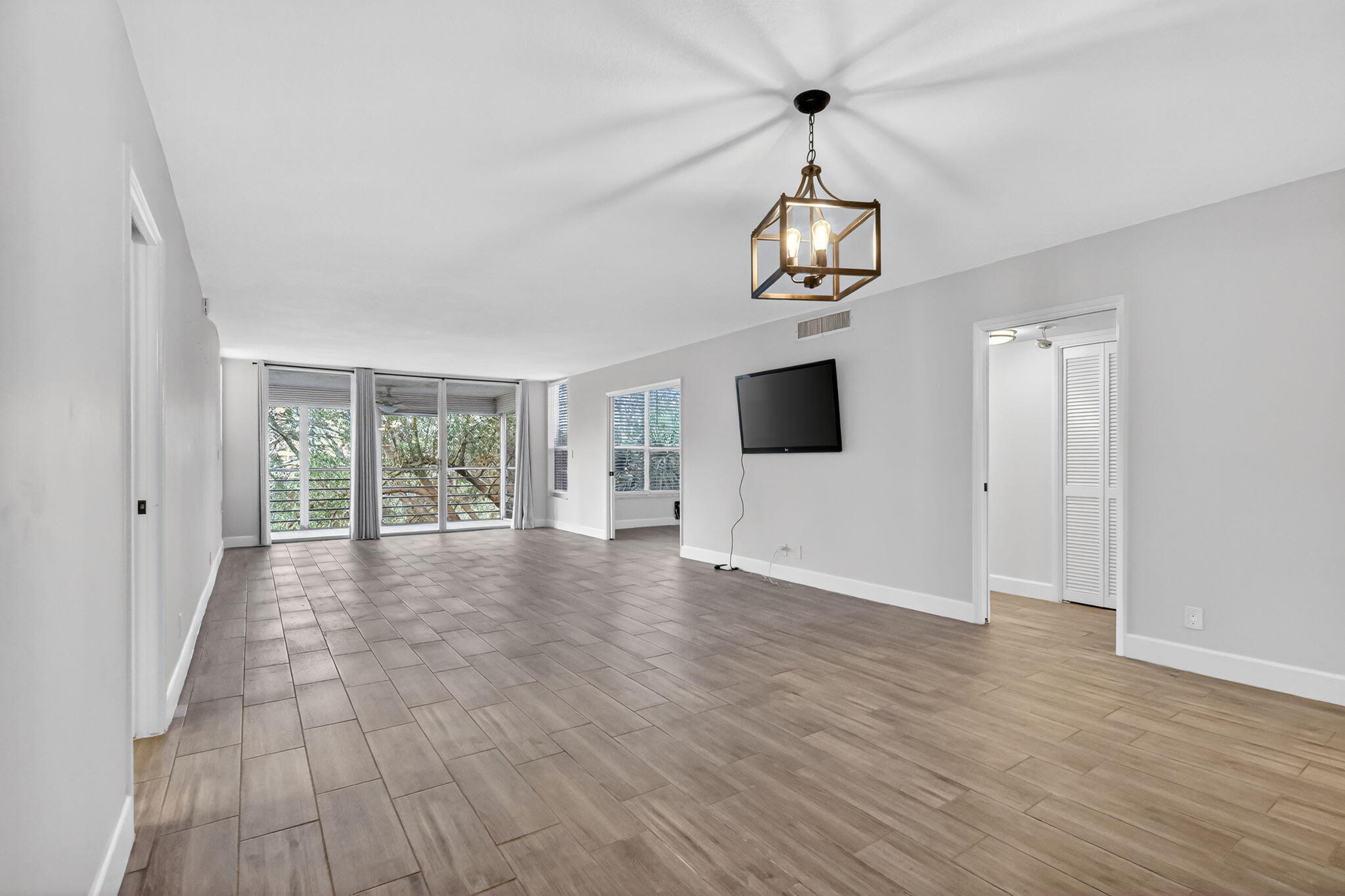 545 Oaks Lane, Unit 409 Pompano Beach, FL 33069 - Photo 7 of 25 a view of a livingroom with wooden floor windows and exposed radiator