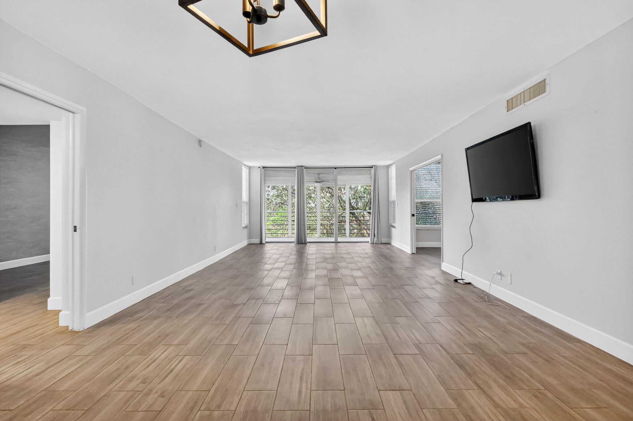 545 Oaks Lane, Unit 409 Pompano Beach, FL 33069 - Photo 8 of 25 a view of a livingroom with wooden floor and a flat screen tv
