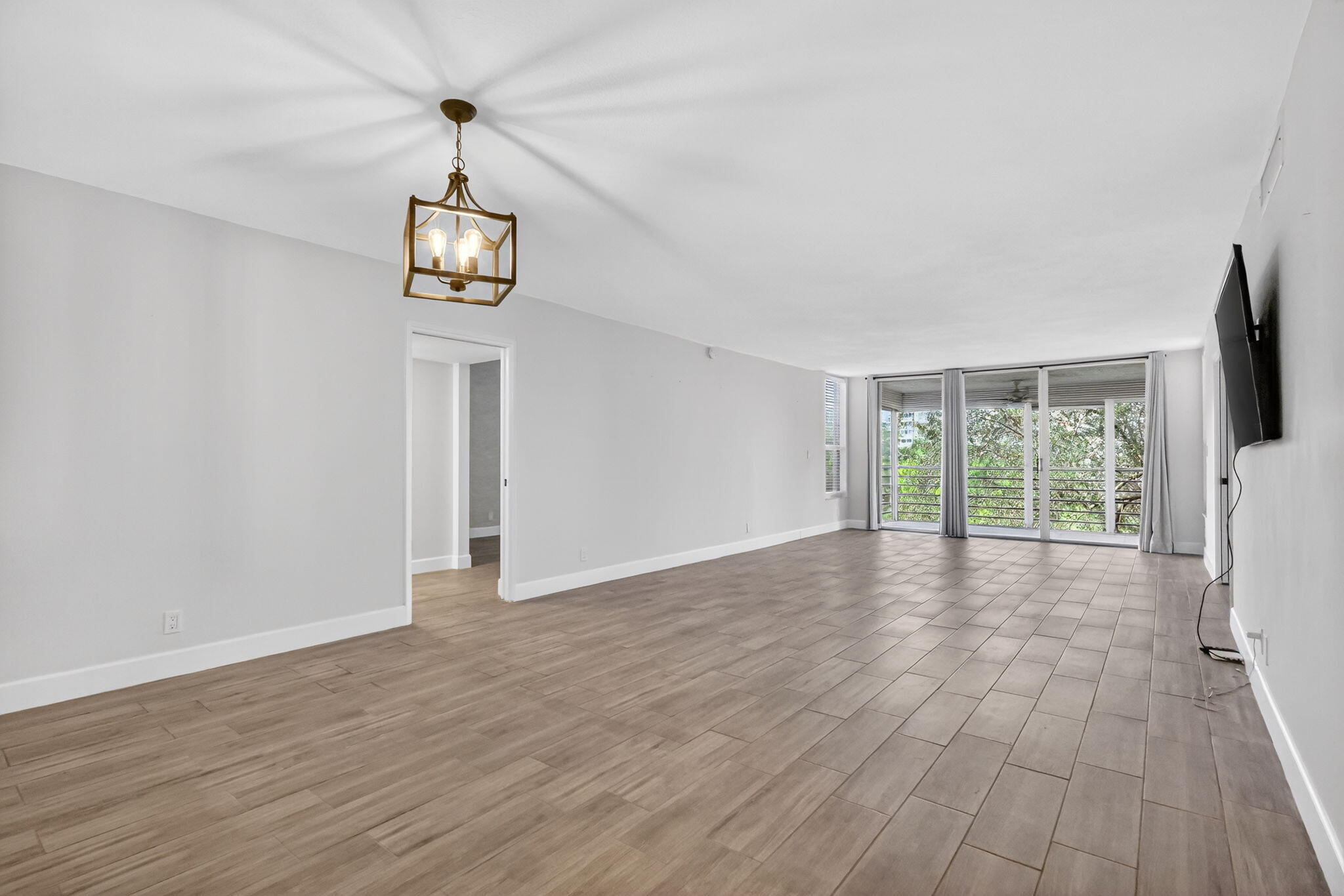 545 Oaks Lane, Unit 409 Pompano Beach, FL 33069 - Photo 9 of 25 a view of empty room with wooden floor and window