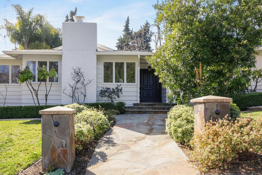 a view of a house with backyard sitting area and garden